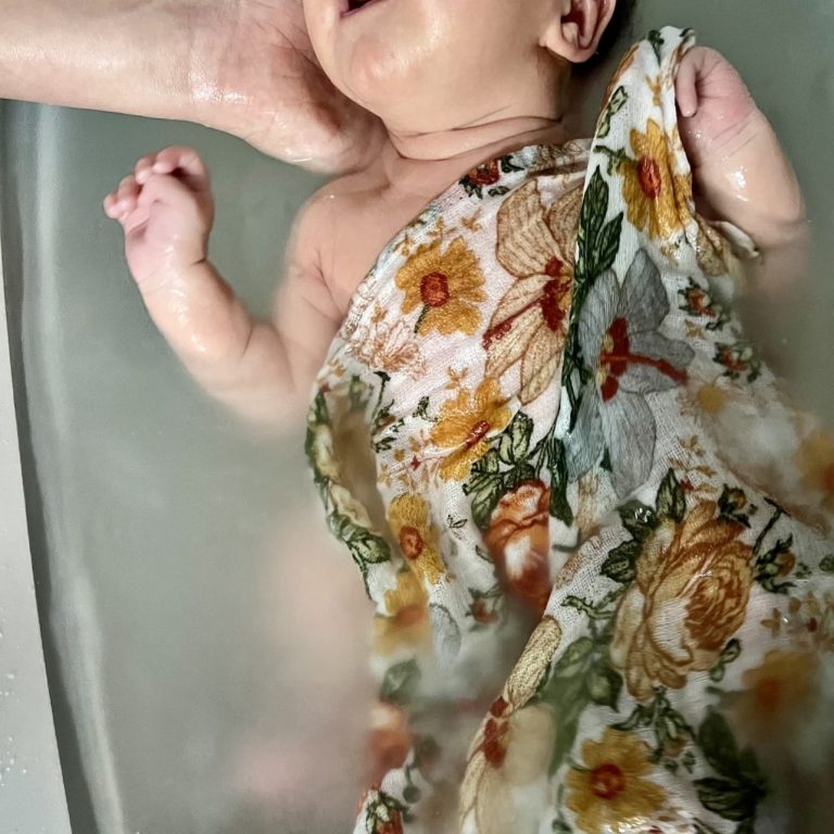 Une baignoire pour bébé est posée sur une table pour donner le bain