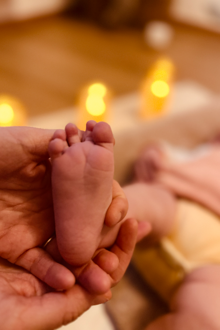 La main d'une maman qui masse le pied de son bébé