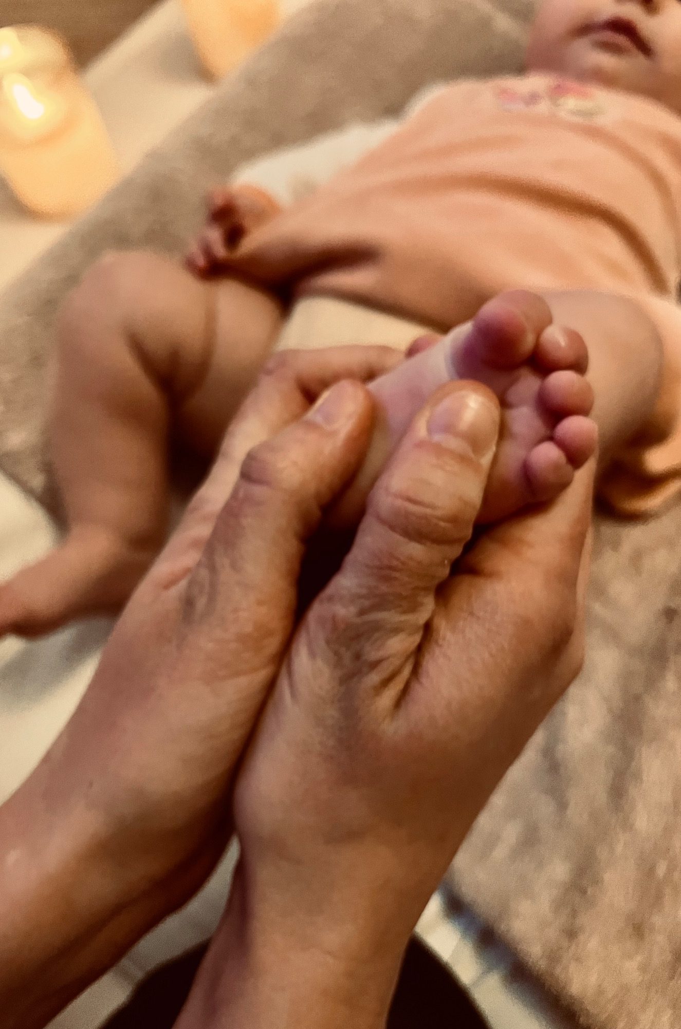 Des mains de parents massent le dos de son bébé